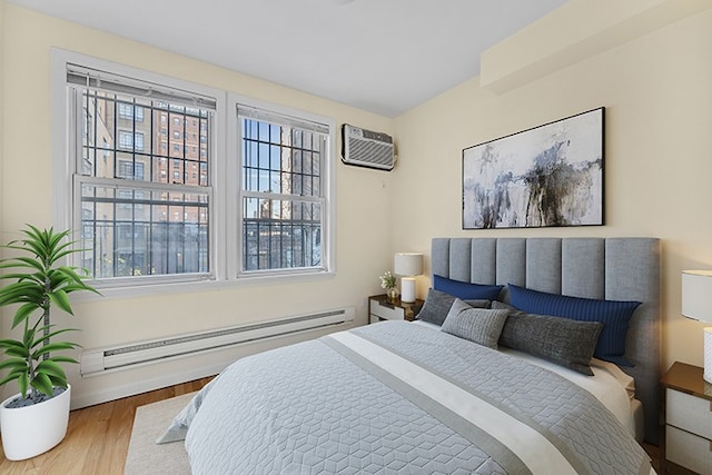 bedroom with a baseboard radiator, wood finished floors, and a wall mounted air conditioner