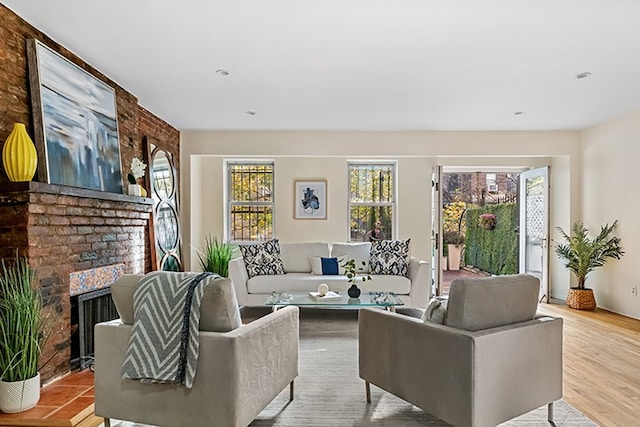 living area featuring a healthy amount of sunlight, a fireplace, and wood finished floors