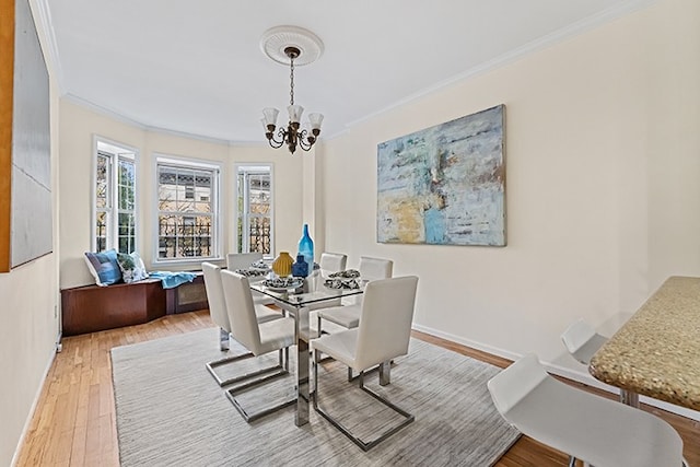 dining area featuring wood finished floors, baseboards, ornamental molding, and an inviting chandelier
