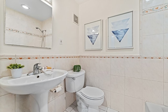 bathroom featuring visible vents, wainscoting, toilet, tile patterned flooring, and tile walls