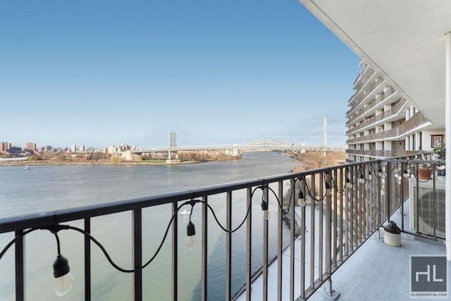 balcony featuring a view of city, a water view, and cooling unit