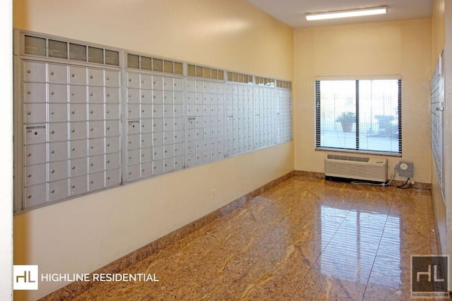 empty room with granite finish floor, baseboards, and a wall mounted AC