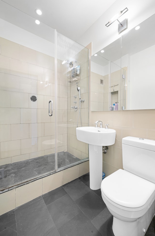 3 Hanover Sq Unit 13F, New York City, NY 10004 - full bathroom featuring a shower stall, toilet, recessed lighting, and tile walls