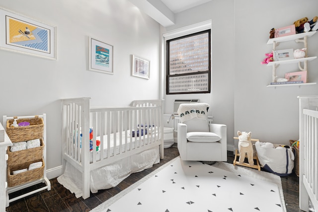 3 Hanover Sq Unit 13F, New York City, NY 10004 - bedroom featuring a crib, wood finished floors, and baseboards