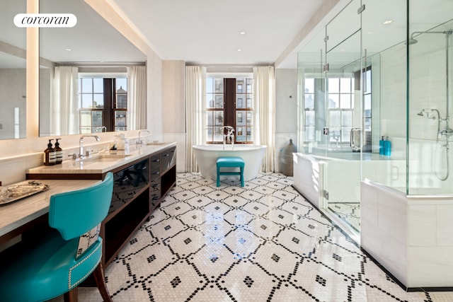 bathroom featuring plenty of natural light, a soaking tub, a shower stall, and vanity