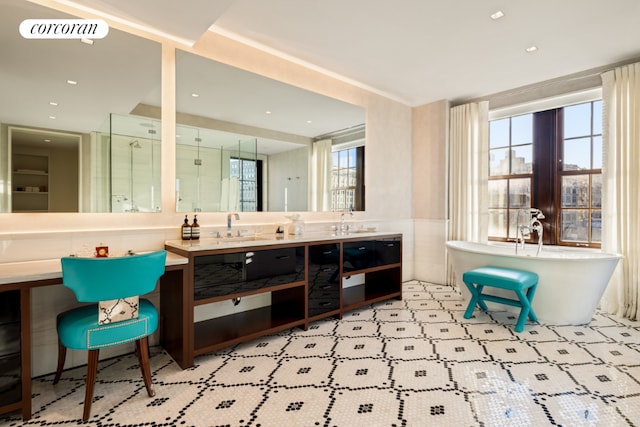 full bathroom featuring double vanity, a stall shower, visible vents, a soaking tub, and a sink