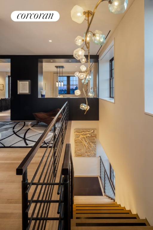 staircase with wood finished floors and a notable chandelier