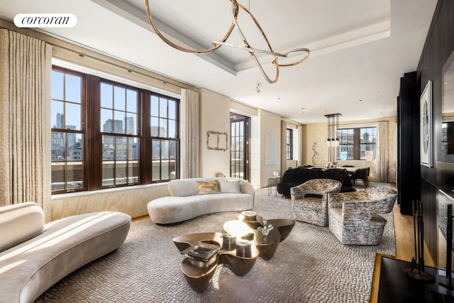 living room with an inviting chandelier, a view of city, visible vents, and a raised ceiling