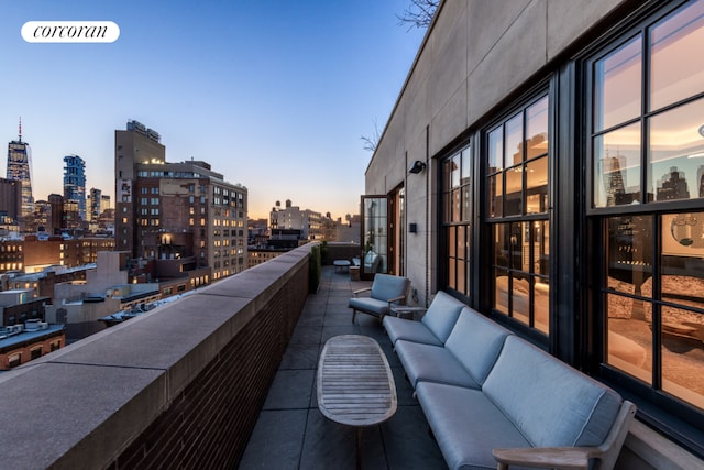 balcony at dusk featuring an outdoor living space