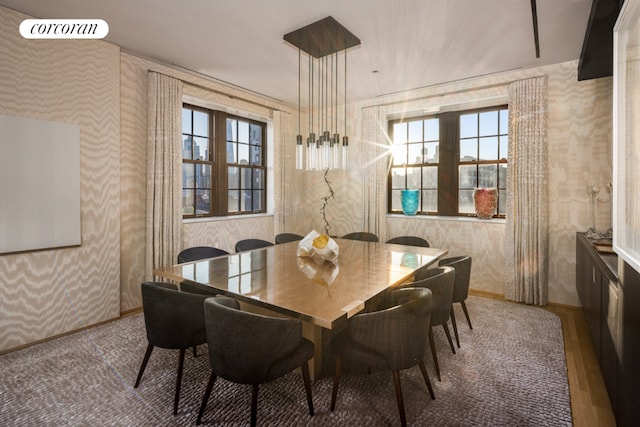 dining space featuring wallpapered walls, baseboards, visible vents, and wood finished floors