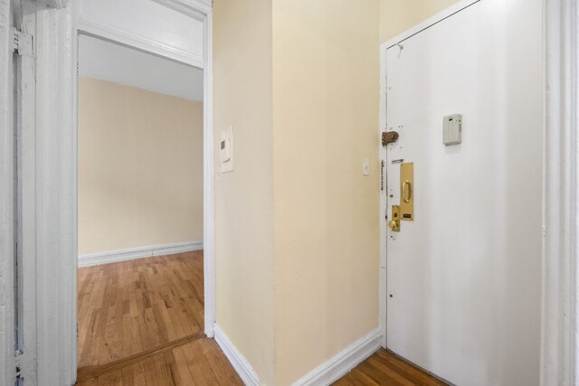 hallway with hardwood / wood-style flooring