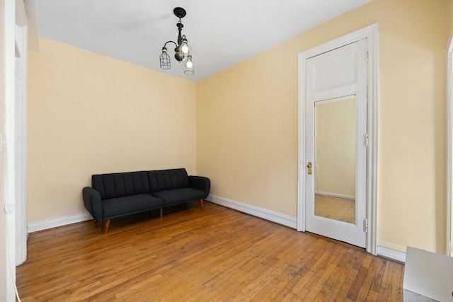 sitting room featuring hardwood / wood-style floors and a chandelier