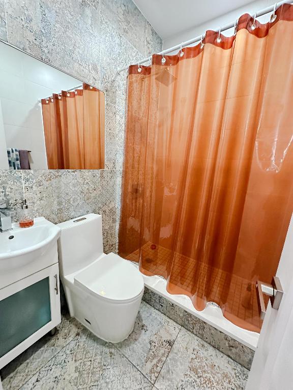 bathroom with toilet, tile walls, and vanity