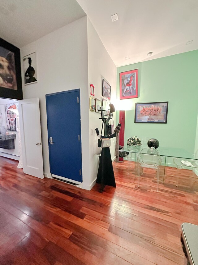 bedroom featuring a baseboard heating unit and hardwood / wood-style flooring