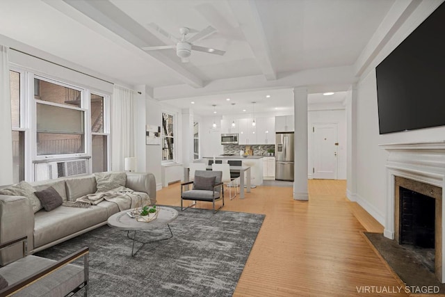 living room featuring beam ceiling, ceiling fan, and light hardwood / wood-style flooring