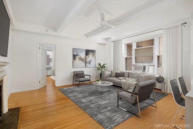 living room with ceiling fan, hardwood / wood-style floors, beamed ceiling, and a premium fireplace