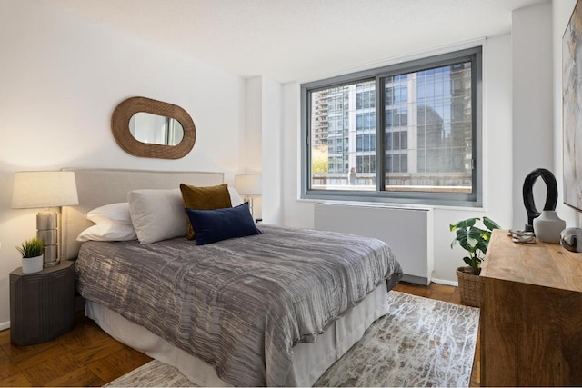 bedroom featuring parquet flooring and radiator