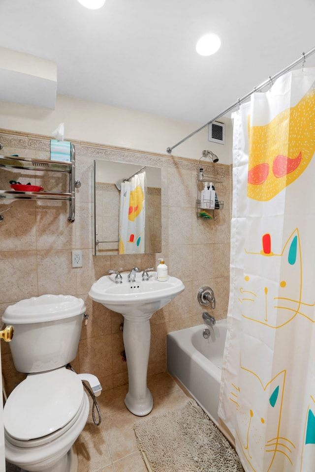 bathroom with toilet, tile patterned floors, visible vents, and tile walls