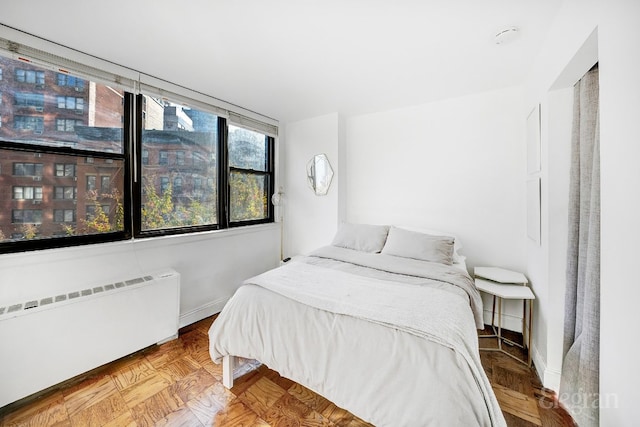 bedroom featuring parquet flooring and radiator heating unit