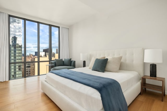 bedroom with light hardwood / wood-style floors and expansive windows