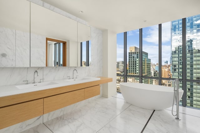 bathroom featuring vanity, floor to ceiling windows, and a tub