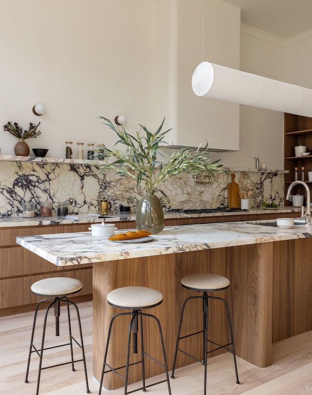 kitchen with tasteful backsplash, brown cabinets, and a sink