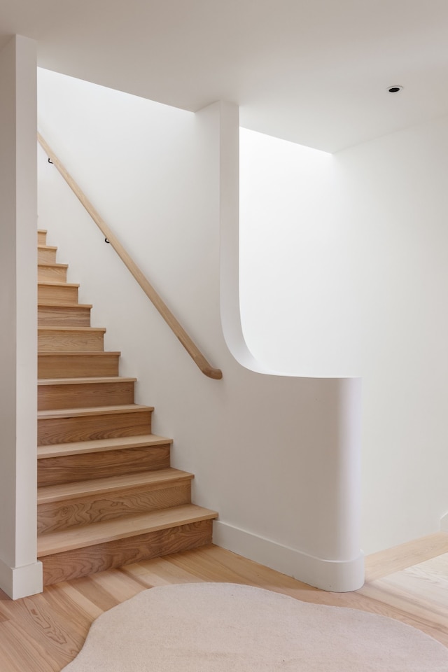 stairway with baseboards and wood finished floors