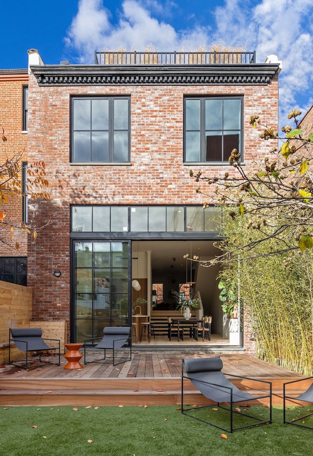 back of property with brick siding and a wooden deck