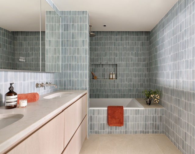 bathroom with double vanity, a sink, tile walls, and tile patterned floors