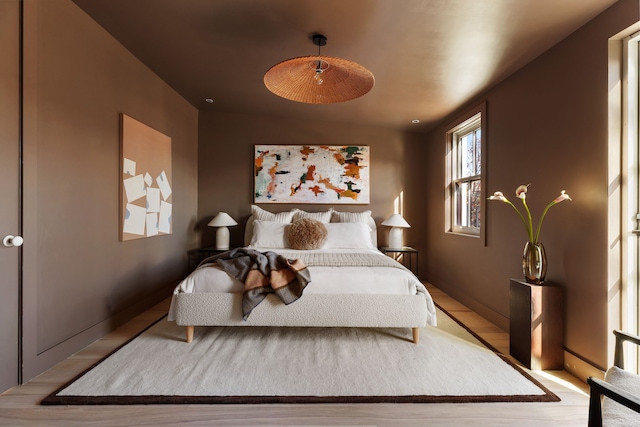 bedroom with baseboards and wood finished floors