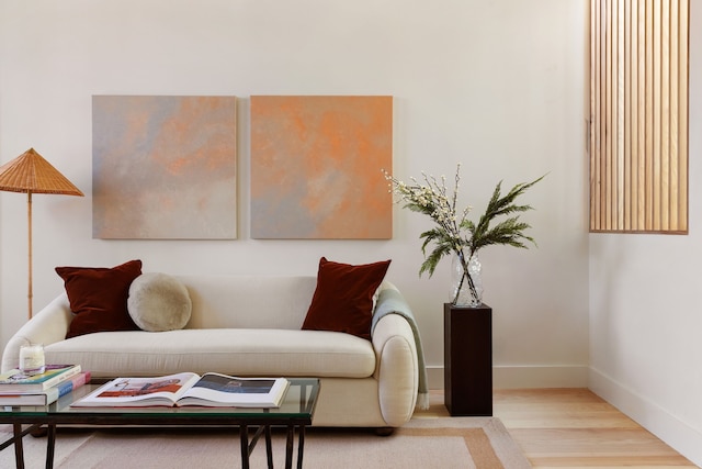 sitting room with baseboards and wood finished floors