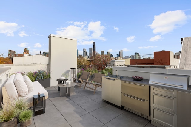 view of patio with exterior kitchen, a city view, and a sink