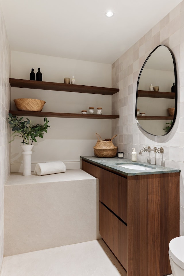 bathroom featuring vanity, recessed lighting, tile walls, toilet, and backsplash