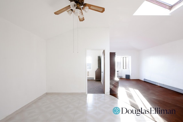 unfurnished room featuring lofted ceiling with skylight, baseboards, a baseboard heating unit, and ceiling fan