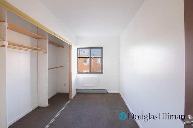 interior space featuring baseboards, a baseboard heating unit, and carpet
