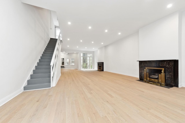38 W 11th St, New York City, NY 10011 - unfurnished living room featuring a fireplace, stairs, light wood-style floors, and recessed lighting