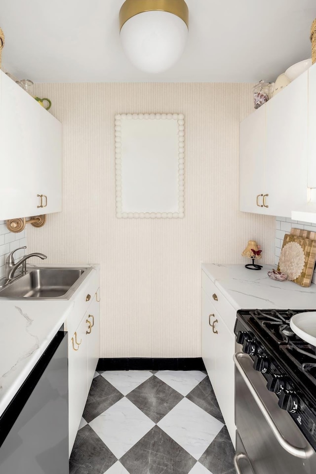 101 W 12th St Unit 12E, New York City, NY 10011 - kitchen with stainless steel appliances, a sink, white cabinetry, baseboards, and tile patterned floors