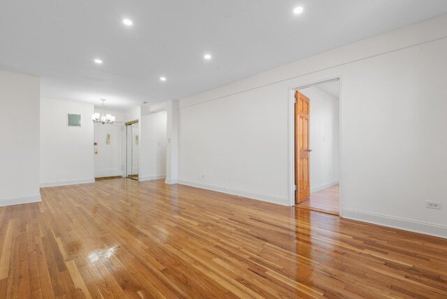 unfurnished room featuring baseboards, visible vents, light wood-type flooring, a chandelier, and recessed lighting