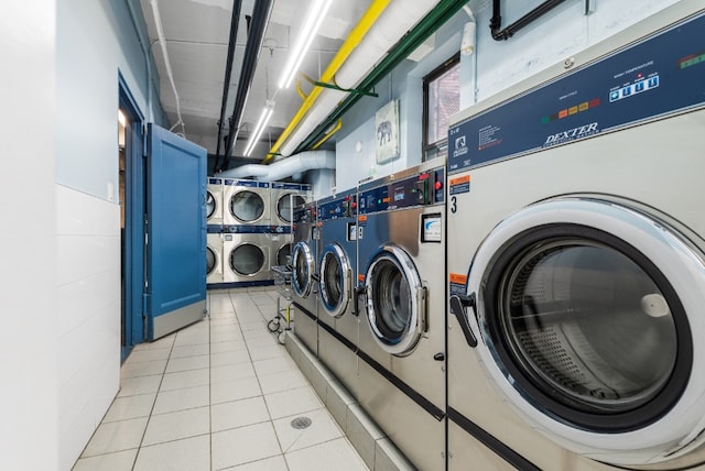 laundry room with stacked washer and dryer, washing machine and dryer, and light tile patterned flooring