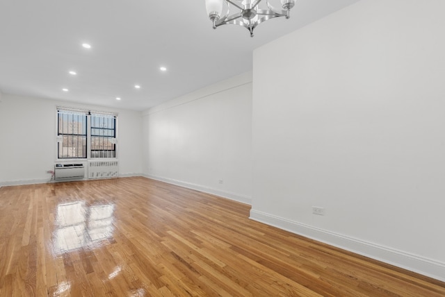 unfurnished living room with a chandelier and light hardwood / wood-style flooring