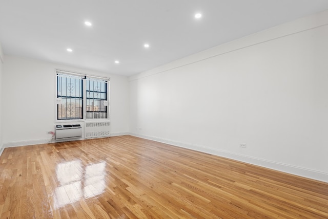 unfurnished living room featuring radiator heating unit, light hardwood / wood-style floors, and heating unit