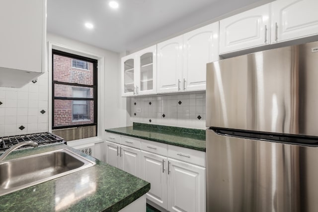 kitchen featuring tasteful backsplash, sink, stainless steel fridge, and white cabinets