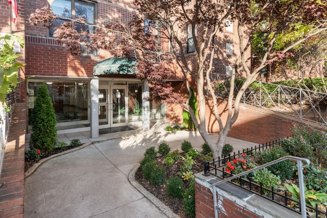 view of exterior entry featuring french doors and brick siding