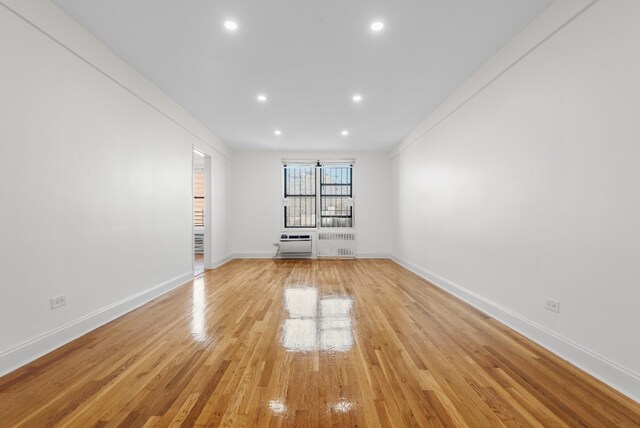 empty room with light wood-style flooring, baseboards, and recessed lighting