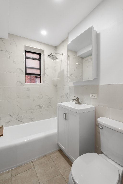 full bathroom with tile patterned floors, toilet, tiled shower / bath, tile walls, and vanity