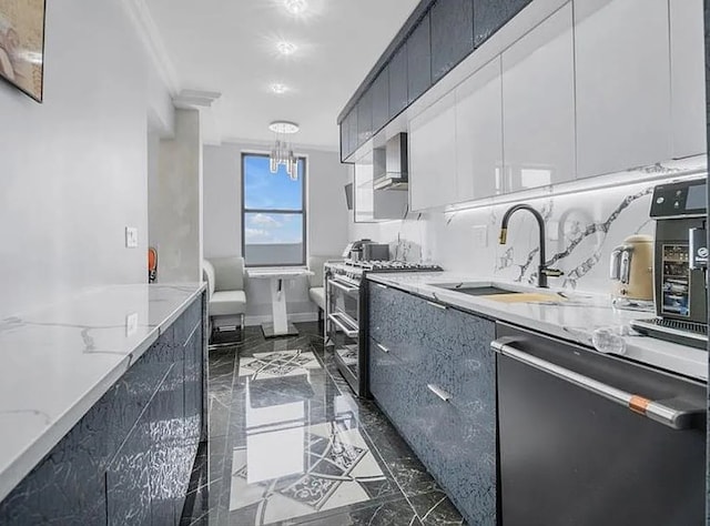 kitchen featuring light stone counters, appliances with stainless steel finishes, a sink, modern cabinets, and dark cabinets