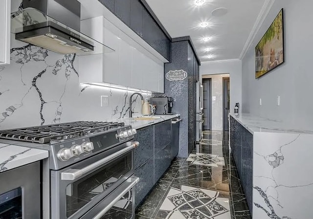 kitchen featuring light stone counters, dark cabinetry, wall chimney range hood, double oven range, and a sink