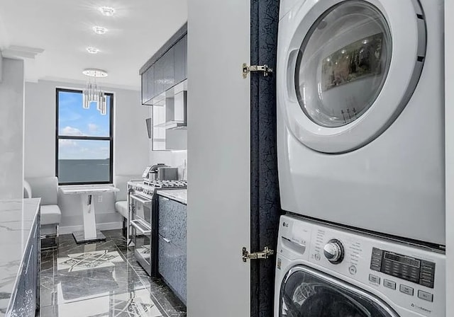 washroom with marble finish floor, baseboards, laundry area, and stacked washer / drying machine