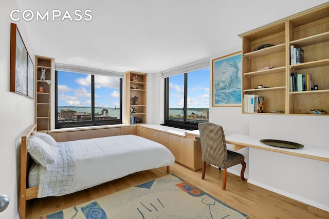 200 Rector Pl Unit 14E, New York City, NY 10280 - bedroom with wood finished floors, built in desk, and baseboards