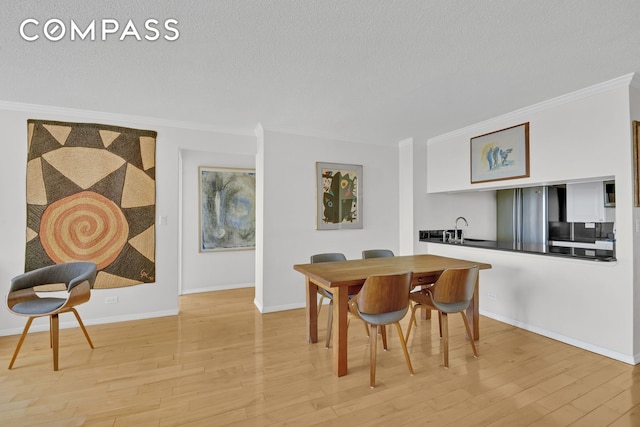200 Rector Pl Unit 14E, New York City, NY 10280 - dining space featuring crown molding, wood finished floors, baseboards, and a textured ceiling